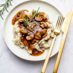 vegan mushroom gravy on potatoes with fork and knife