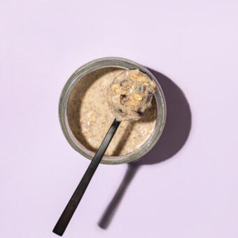 black spoon of overnight oats on top of jar